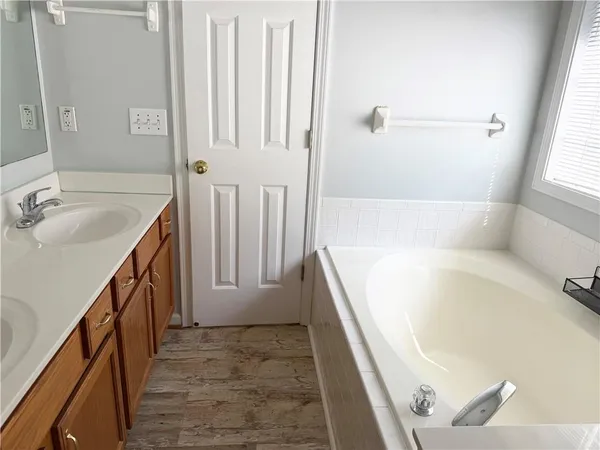a bathroom with a tub sink and mirror