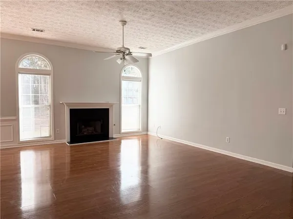a view of empty room with wooden floor fireplace and windows