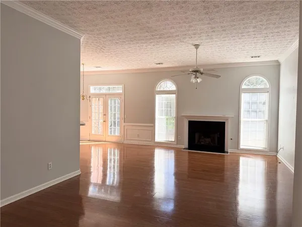 a view of empty room with wooden floor and fireplace