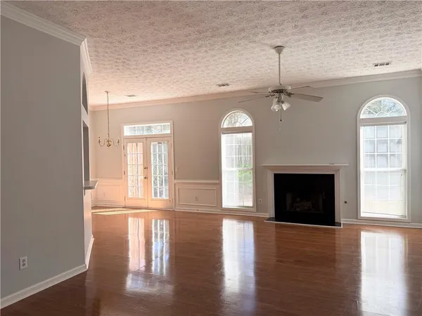 a view of empty room with wooden floor and fireplace