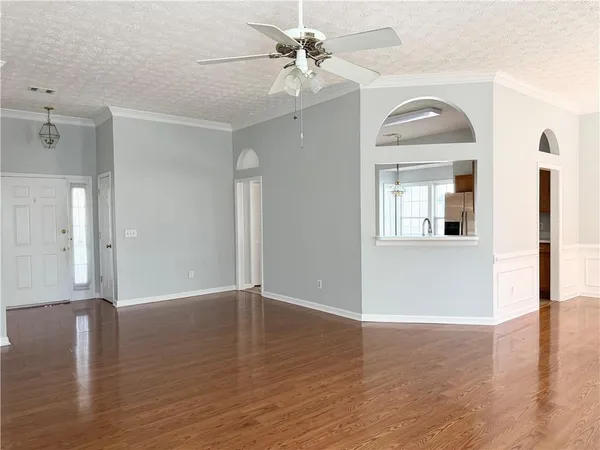 a view of a room with wooden floor and a ceiling fan