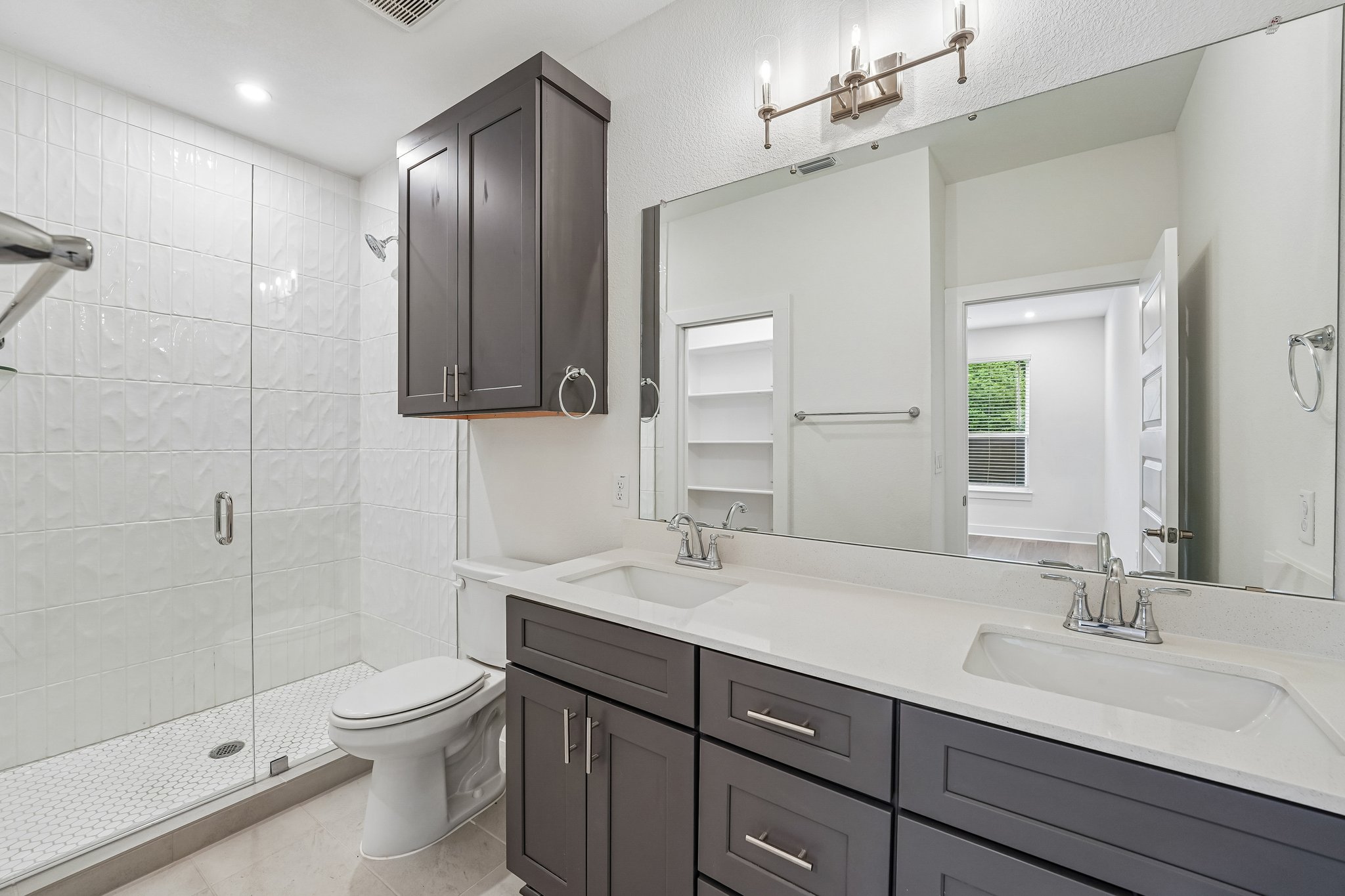 200 West 56th Street, Unit 2103 Austin, TX 78751 - Photo 10 of 26 The primary ensuite features a
dual quartz vanity and And an oversized walk in shower
with subway tile surround, enclosed by frameless glass.