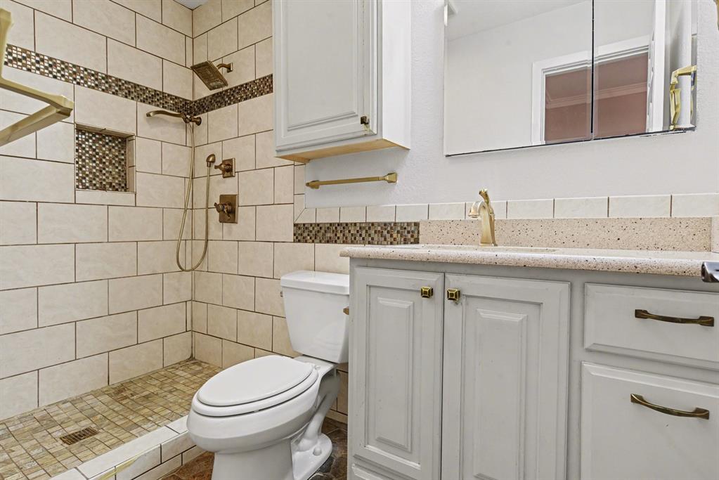 5926 Rosehill Road Garland, TX 75043 - Photo 14 of 26 a bathroom with a granite countertop sink toilet and shower