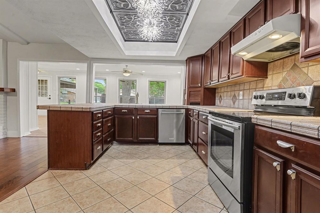 5926 Rosehill Road Garland, TX 75043 - Photo 7 of 26 a kitchen with stainless steel appliances granite countertop a stove a sink dishwasher and a refrigerator