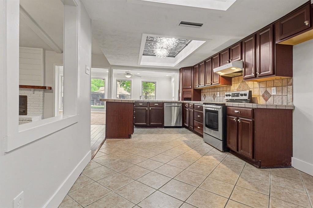 5926 Rosehill Road Garland, TX 75043 - Photo 8 of 26 a large kitchen with stainless steel appliances granite countertop a stove and a sink