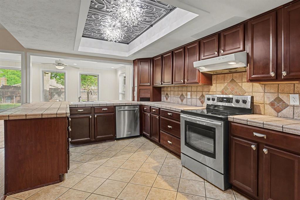 5926 Rosehill Road Garland, TX 75043 - Photo 9 of 26 a kitchen with stainless steel appliances granite countertop a stove sink and cabinets