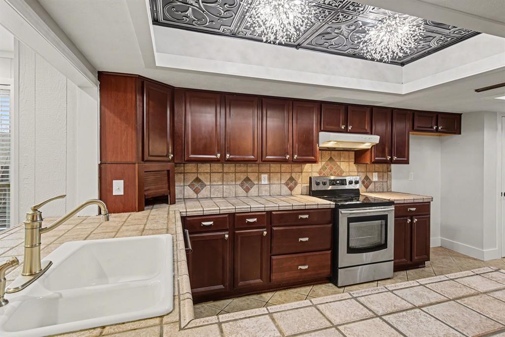 5926 Rosehill Road Garland, TX 75043 - Photo 10 of 26 a kitchen with stainless steel appliances granite countertop a sink stove and cabinets
