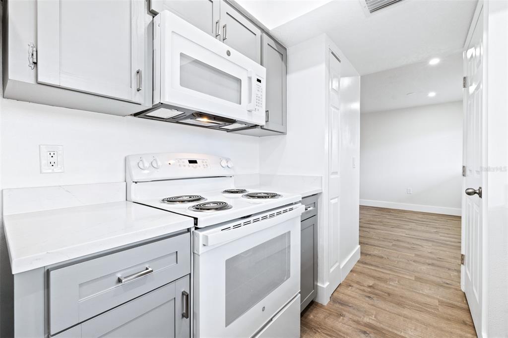 2003 Greenbriar Boulevard, Unit 16 Clearwater, FL 33763 - Photo 12 of 56 a kitchen with white cabinets and white appliances