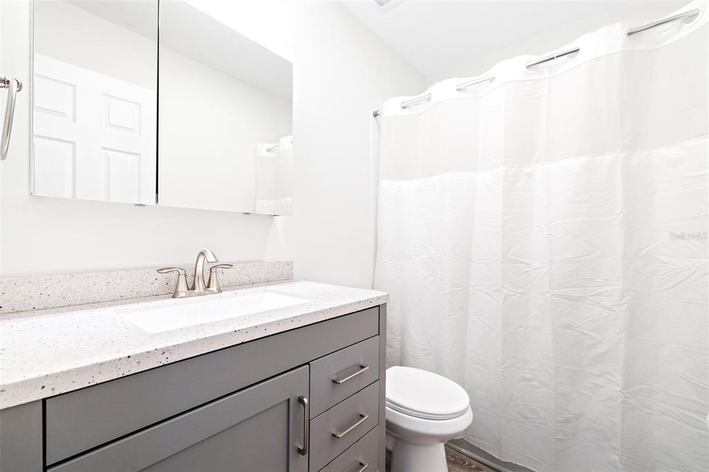2003 Greenbriar Boulevard, Unit 16 Clearwater, FL 33763 - Photo 20 of 56 a bathroom with a granite countertop sink a toilet and a mirror