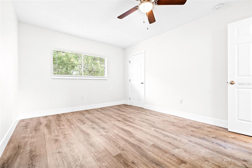 2003 Greenbriar Boulevard, Unit 16 Clearwater, FL 33763 - Photo 24 of 56 a view of an empty room with wooden floor and a window