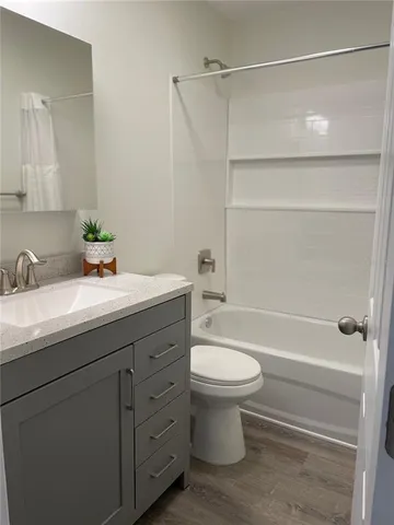 a bathroom with a granite countertop sink and a toilet