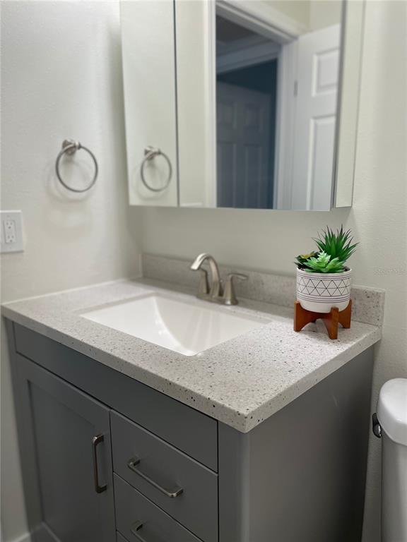 2003 Greenbriar Boulevard, Unit 16 Clearwater, FL 33763 - Photo 48 of 56 a bathroom with a granite countertop sink and a mirror