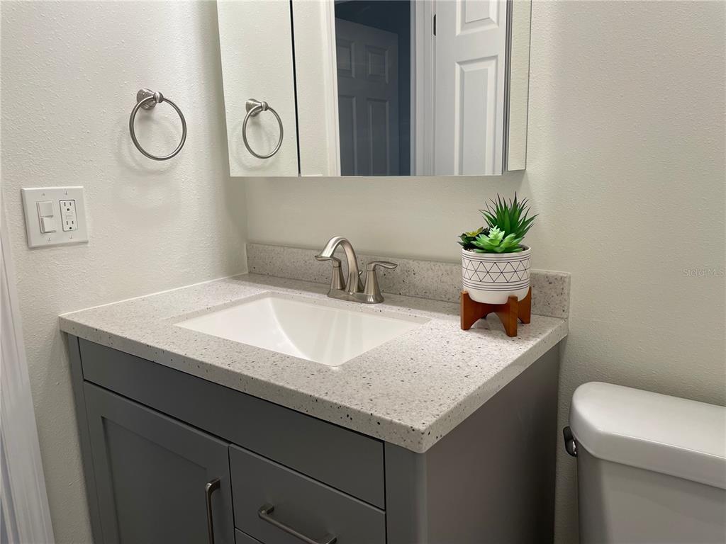 2003 Greenbriar Boulevard, Unit 16 Clearwater, FL 33763 - Photo 49 of 56 a bathroom with a granite countertop sink and a toilet