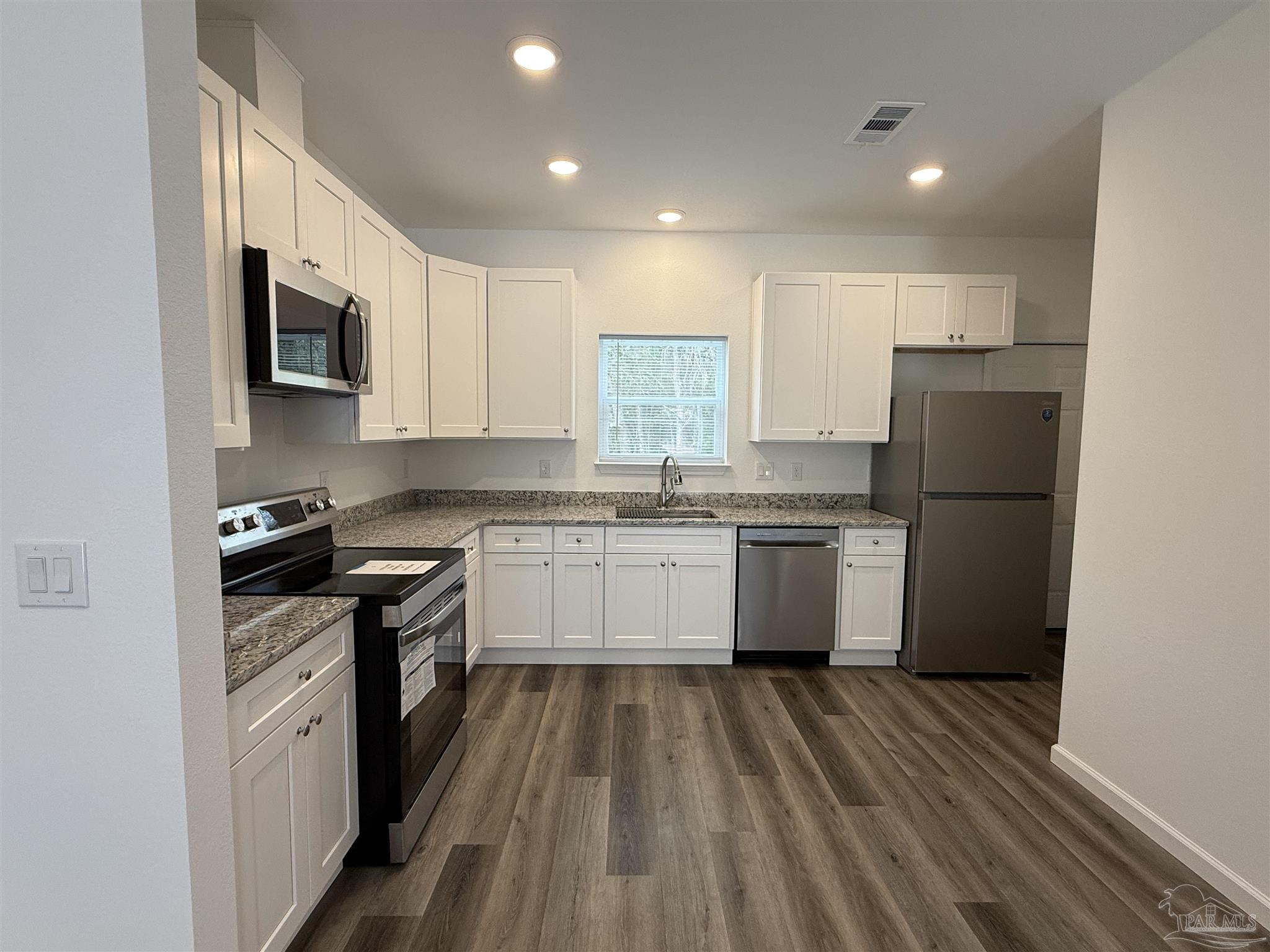 654 Nix Road Pensacola, FL 32506 - Photo 3 of 11 a kitchen with a white stove top oven and refrigerator