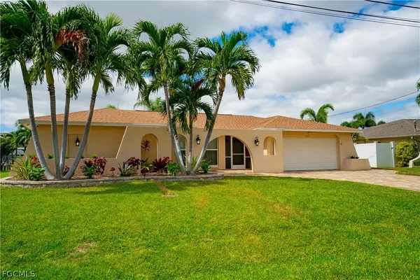 a front view of house with yard and car parked