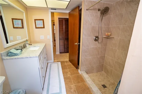a bathroom with a granite countertop sink a mirror and shower