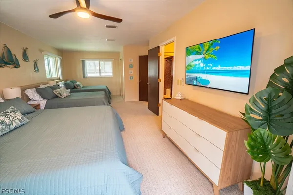 a spacious bedroom with a bed and a flat screen tv