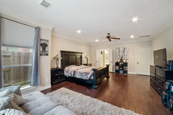 a spacious bedroom with a bed and a flat screen television