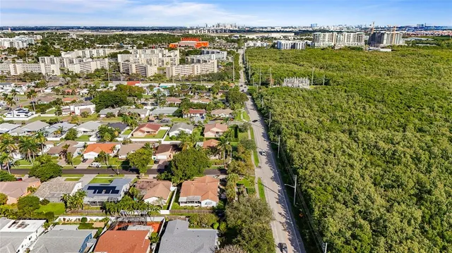 a front view of a house with a yard and palm trees