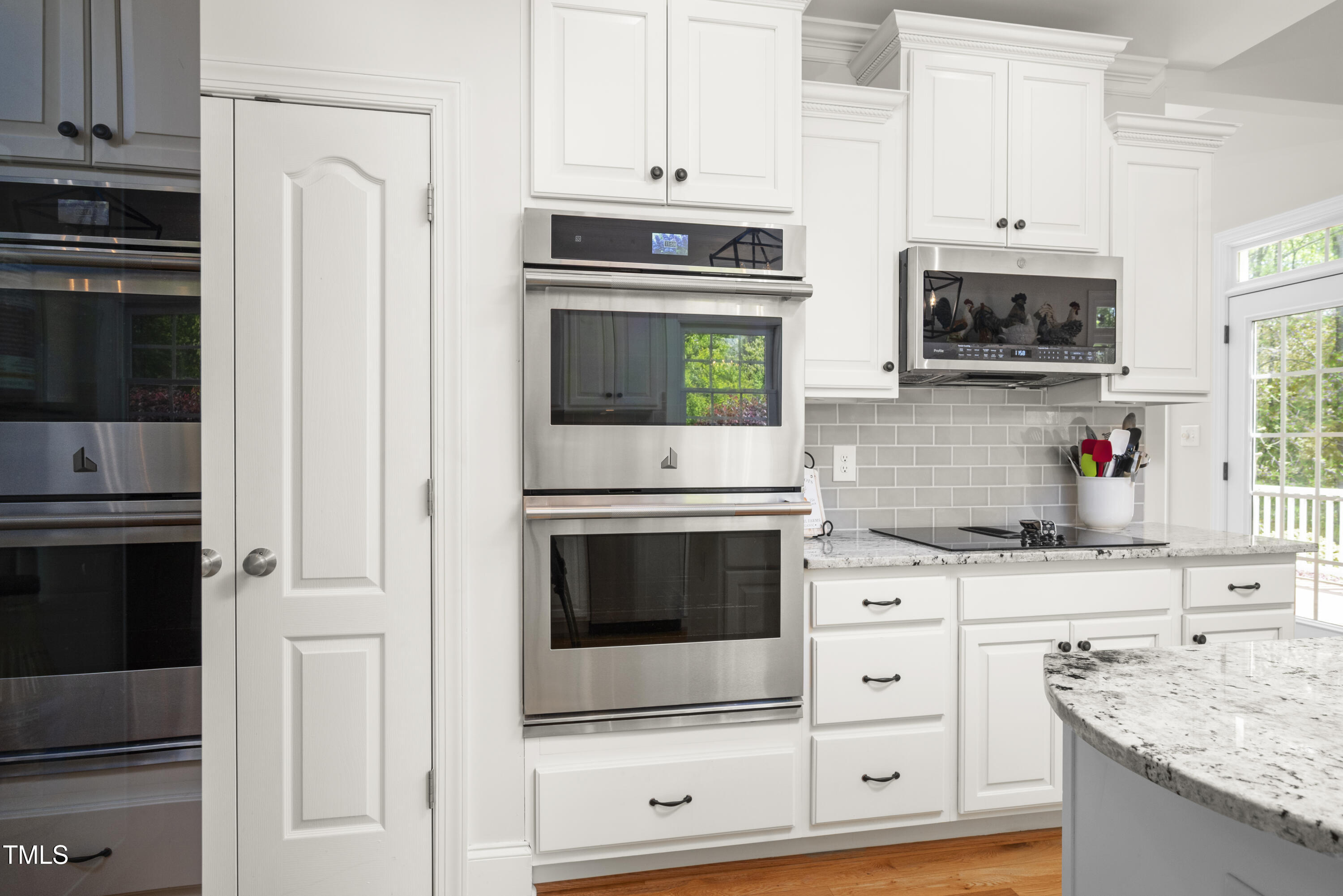 8480 Falkirk Ridge Court Wake Forest, NC 27587 - Photo 25 of 63 a kitchen with stainless steel appliances white cabinets and a stove a oven with wooden floor