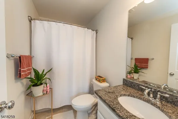 a bath room with a granite countertop sink and a mirror