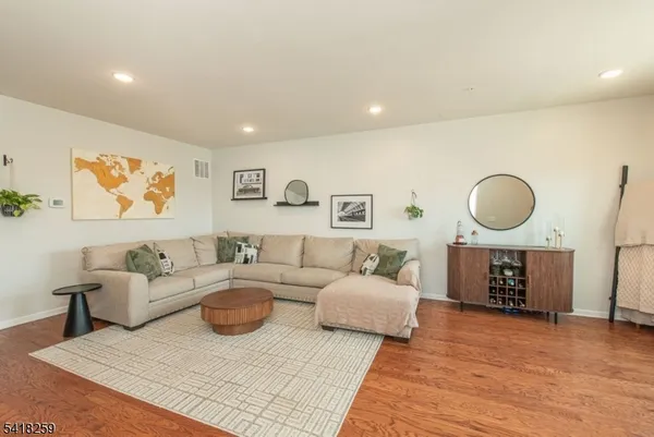 a living room with furniture a rug and a large mirror