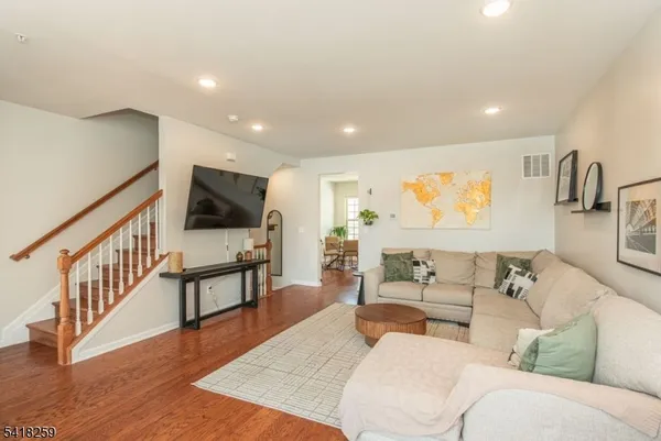 a living room with furniture wooden floor and a flat screen tv