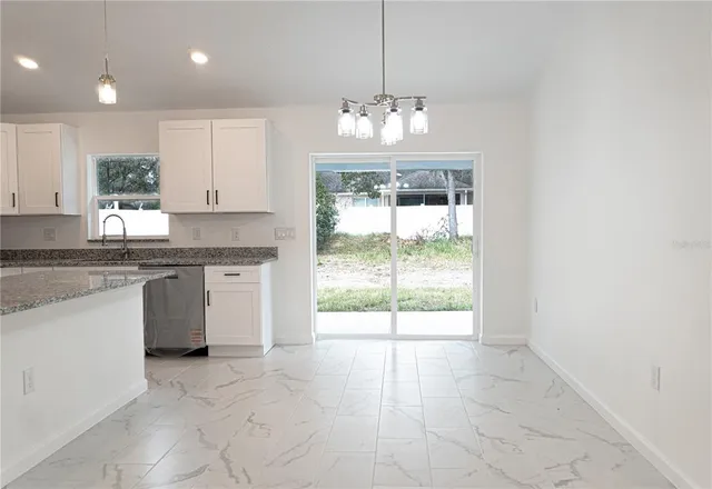 a view of kitchen with granite countertop stove top oven and cabinets
