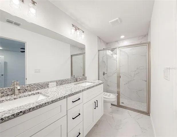 a bathroom with a granite countertop sink a mirror a shower and a bathtub