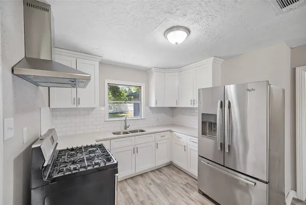 a kitchen with stainless steel appliances a refrigerator sink and cabinets