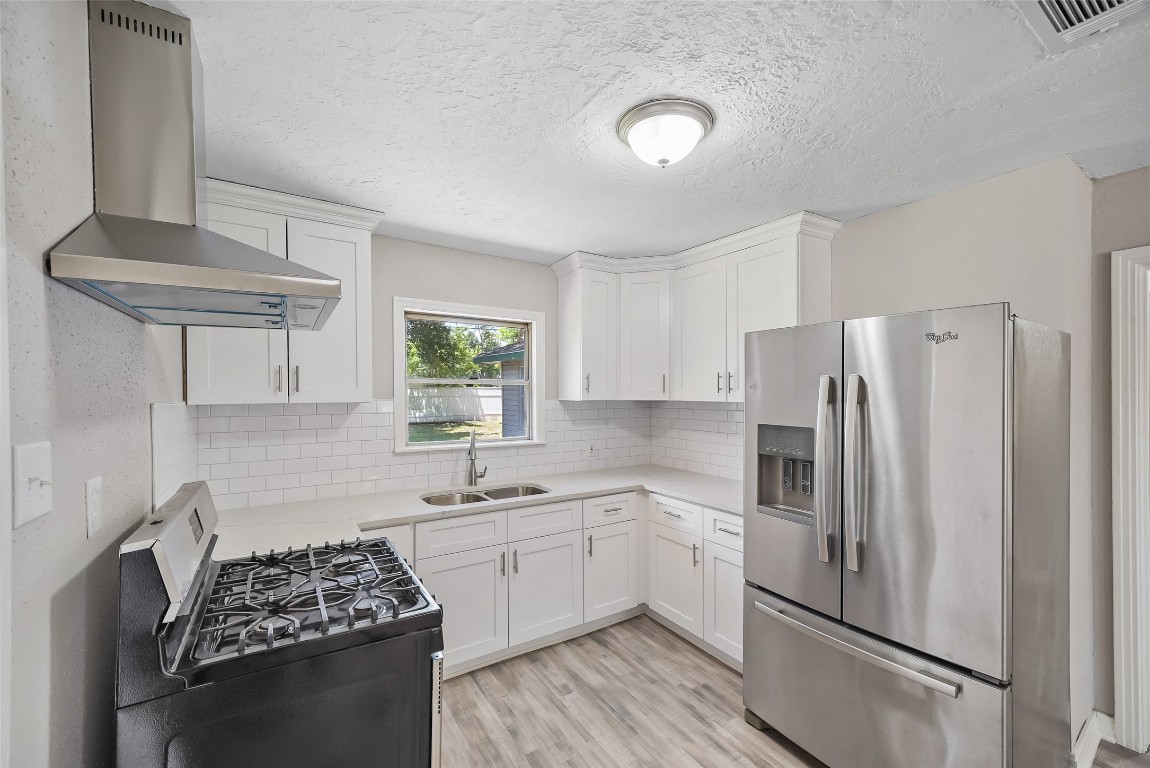 a kitchen with stainless steel appliances a refrigerator sink and cabinets