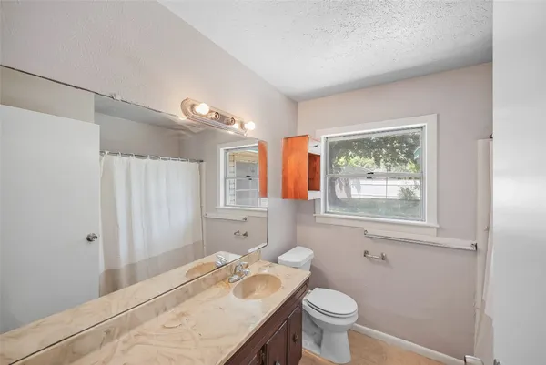 a bathroom with a granite countertop sink toilet and shower