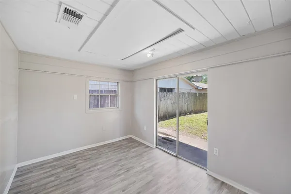 a view of an empty room with wooden floor