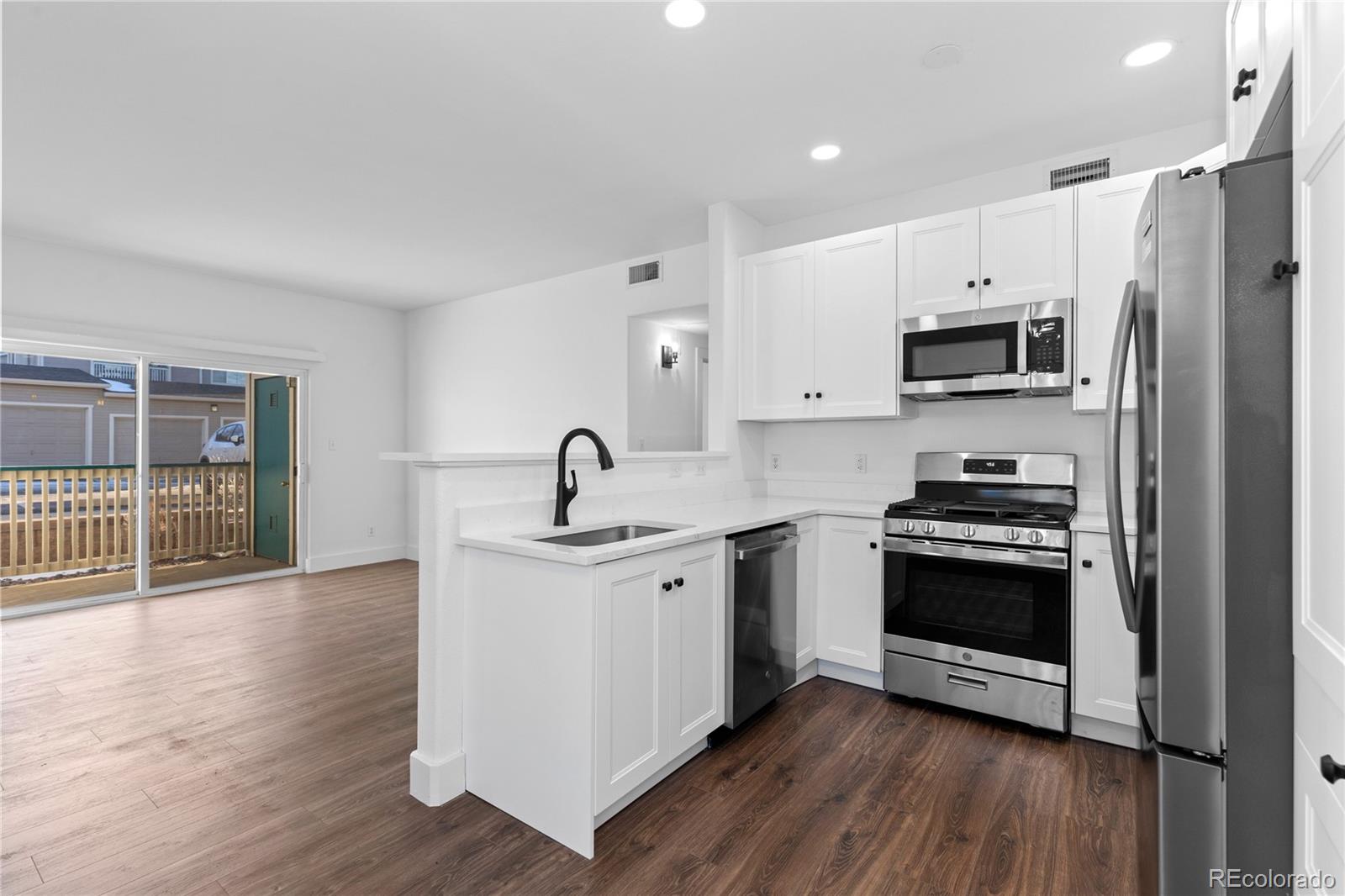 3855 East Canyon Ranch Road, Unit 104 Highlands Ranch, CO 80126 - Photo 15 of 36 a kitchen with stainless steel appliances a stove a sink and a refrigerator