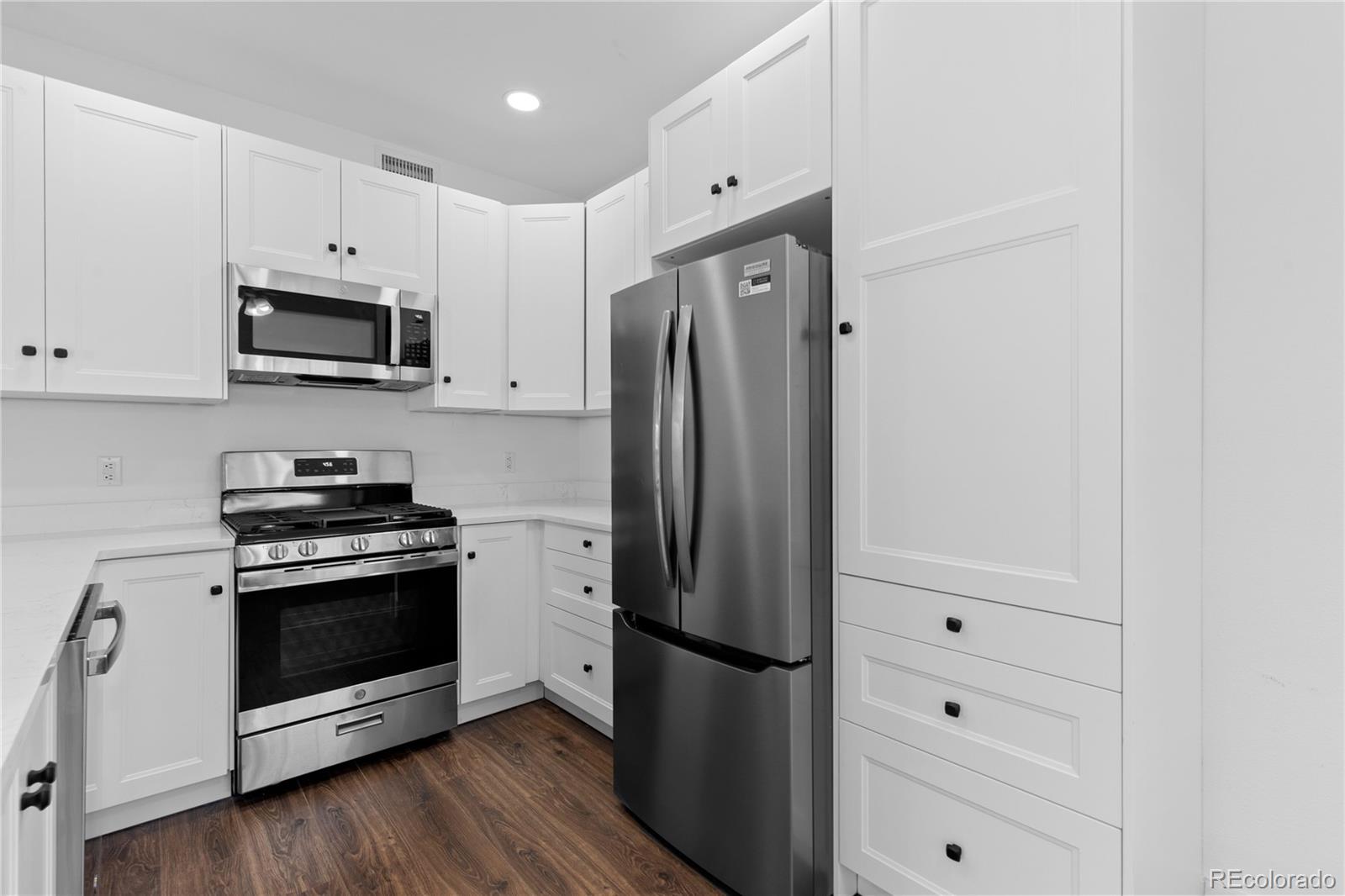 3855 East Canyon Ranch Road, Unit 104 Highlands Ranch, CO 80126 - Photo 16 of 36 a kitchen with stainless steel appliances white cabinets and a refrigerator