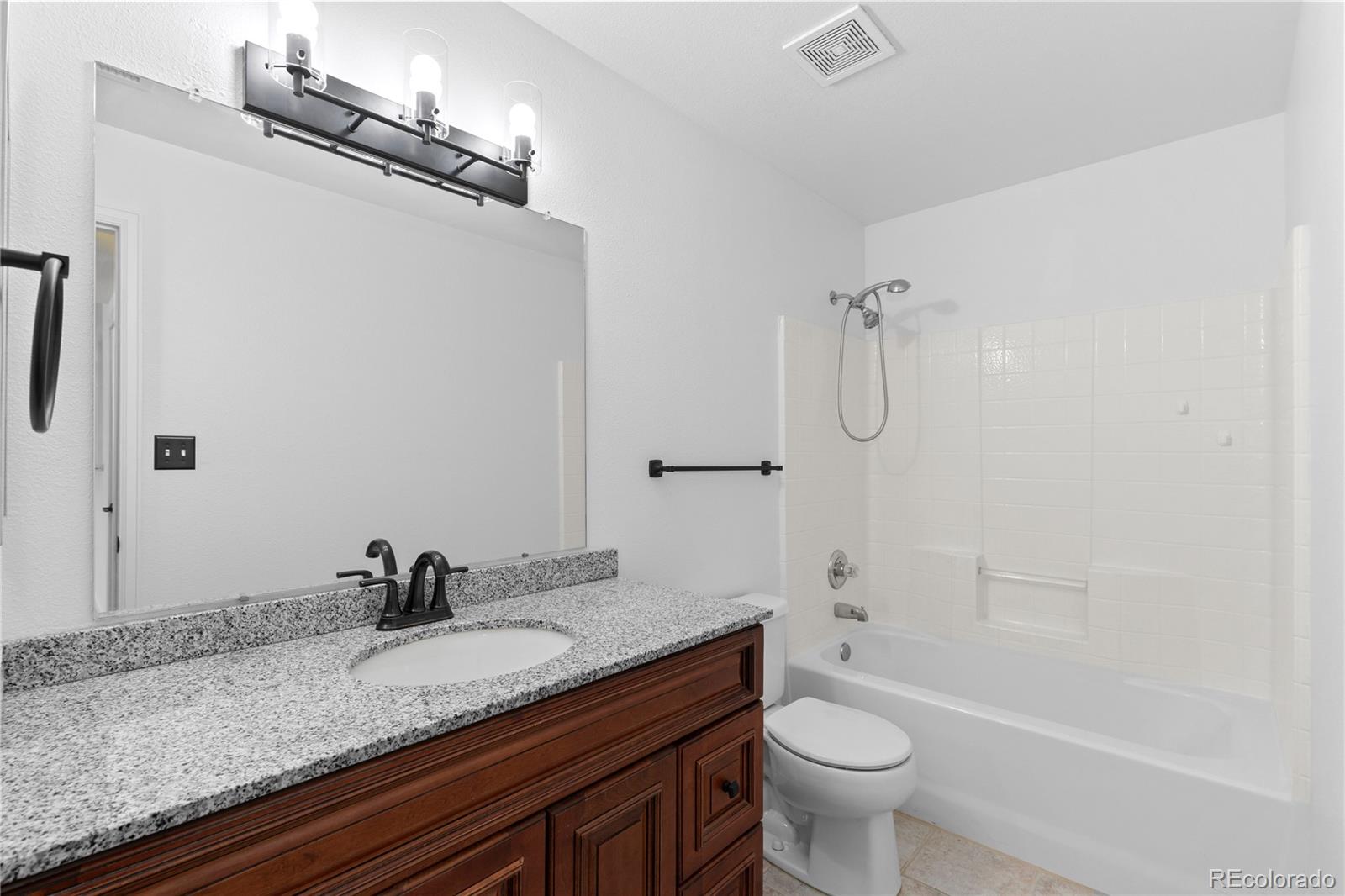 3855 East Canyon Ranch Road, Unit 104 Highlands Ranch, CO 80126 - Photo 25 of 36 a bathroom with a granite countertop sink toilet and shower