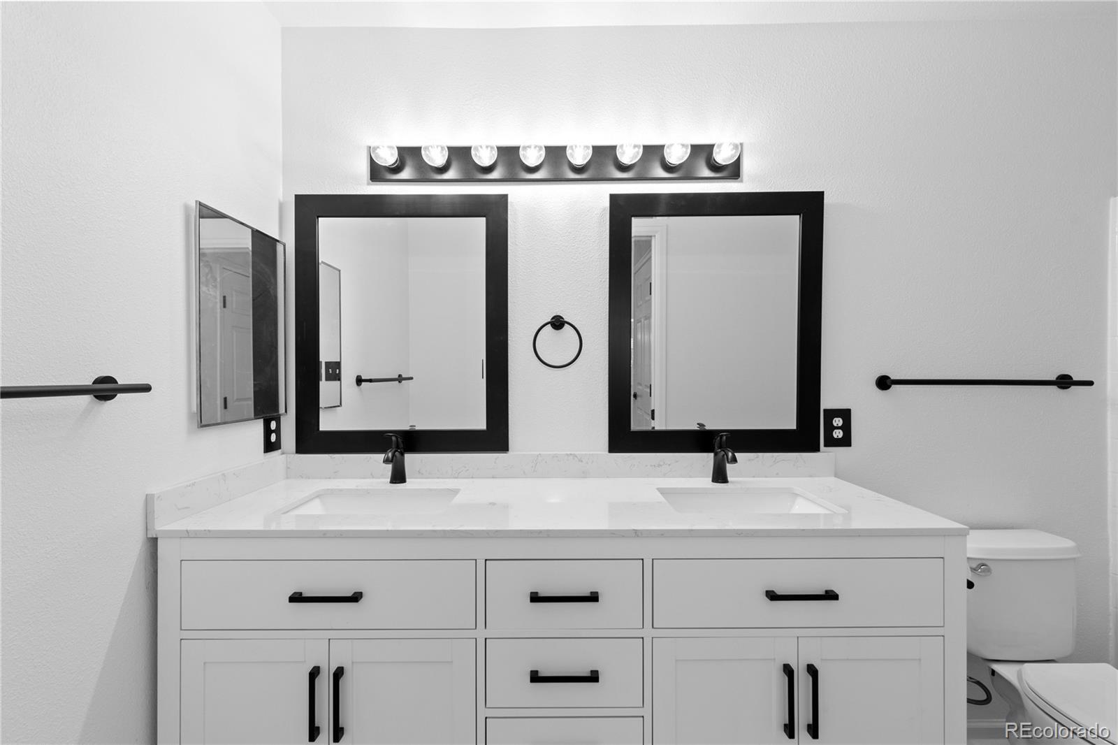 3855 East Canyon Ranch Road, Unit 104 Highlands Ranch, CO 80126 - Photo 30 of 36 a bathroom with double vanity sink and mirror