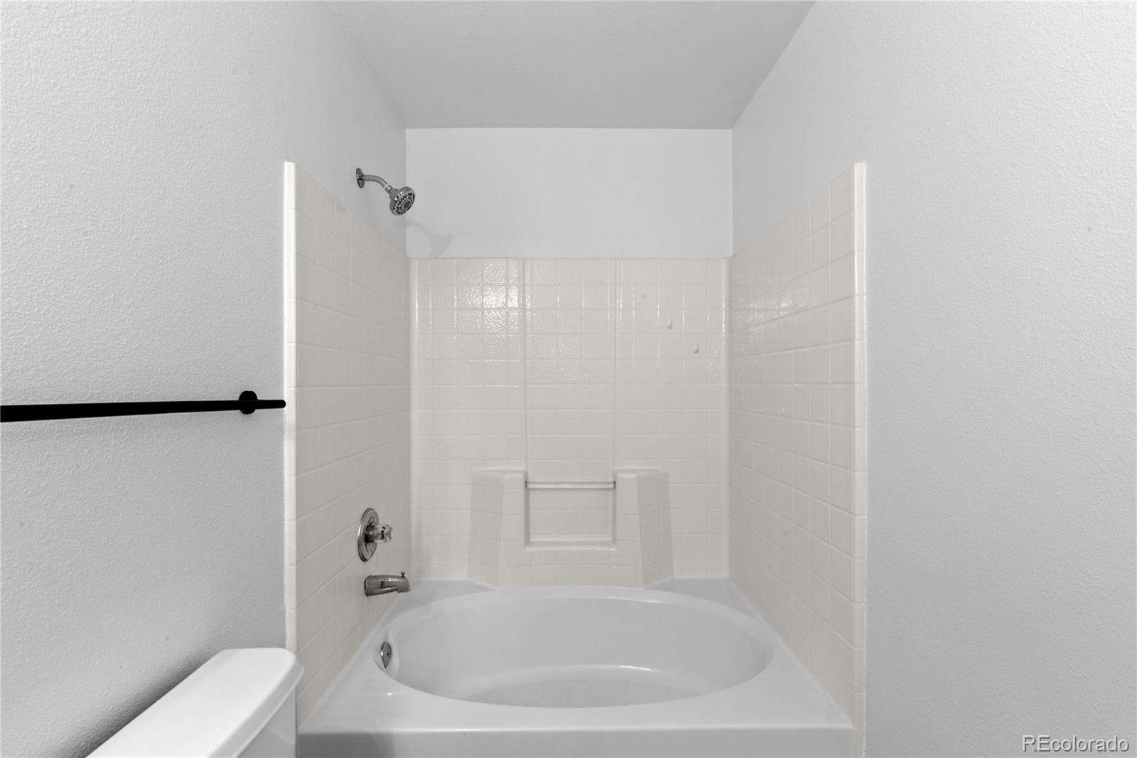 3855 East Canyon Ranch Road, Unit 104 Highlands Ranch, CO 80126 - Photo 31 of 36 a white bath tub sitting next to a white toilet