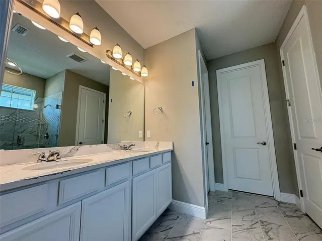 a spacious bathroom with a double vanity sink mirror and double
