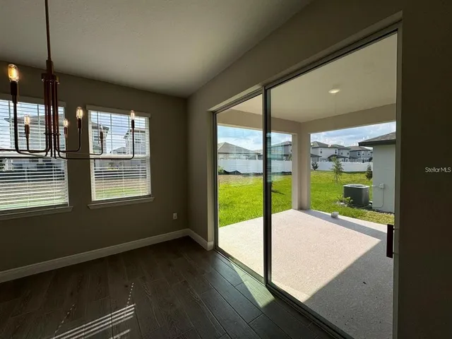 a view of an empty room with wooden floor and a floor to ceiling window