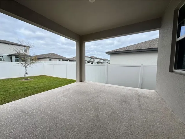 a view of a house with a big yard and large tree