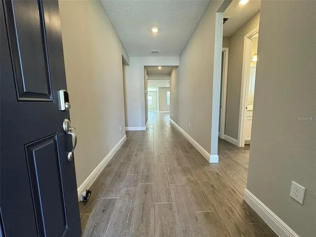 a view of a hallway with wooden floor