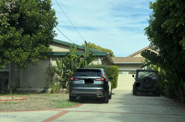 a car parked in front of a white house