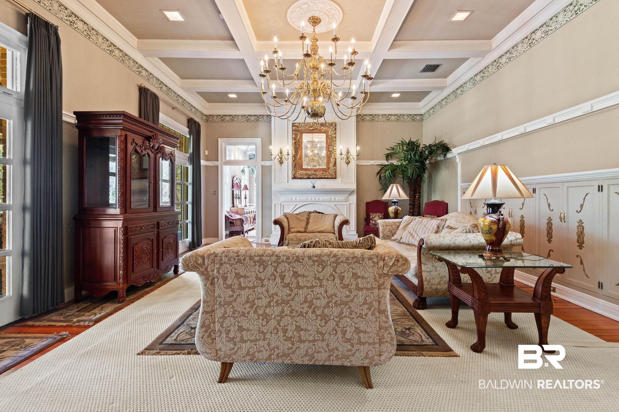 1701 Sowell Road Brewton, AL 36426 - Photo 18 of 83 Living room featuring coffered ceiling, crown molding, a chandelier, wood finished floors, and a fireplace