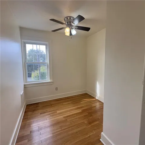 a view of empty room with window and wooden floor