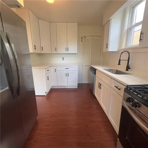 a kitchen with stainless steel appliances a sink stove refrigerator and cabinets