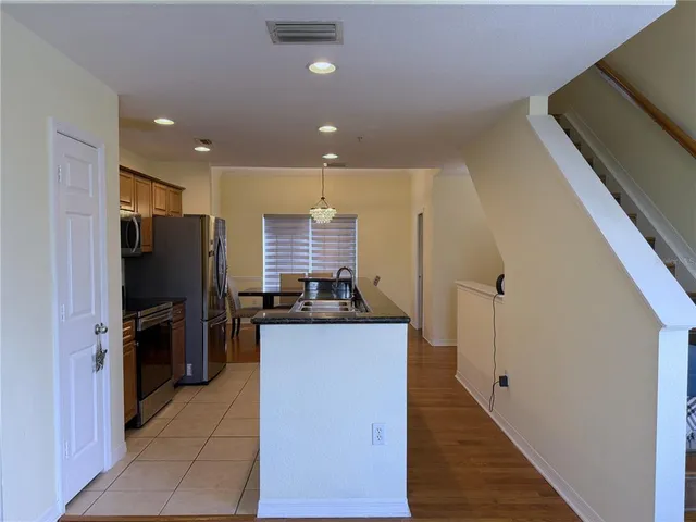 a kitchen with stainless steel appliances granite countertop a refrigerator a stove and a sink