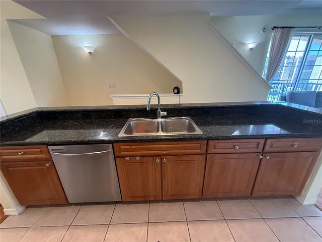 a kitchen with granite countertop a sink and cabinets