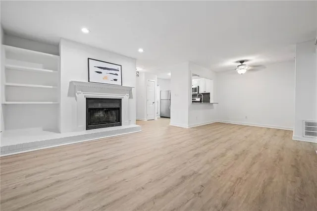 a view of empty room with wooden floor and fireplace