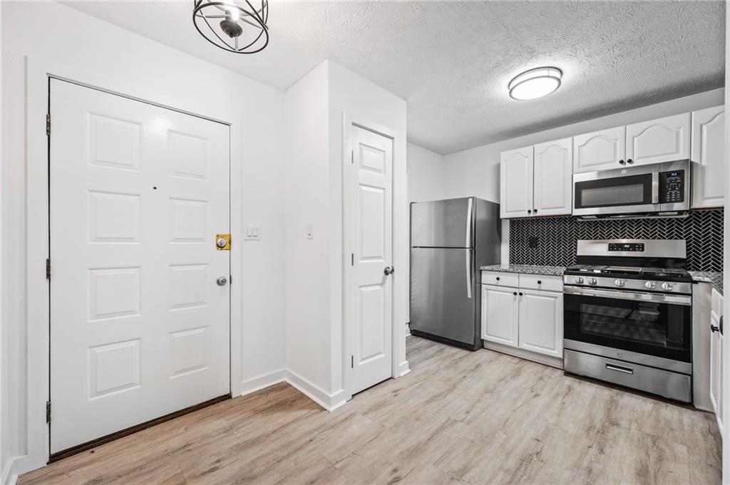 102 River Run Drive Atlanta, GA 30350 - Photo 11 of 28 a kitchen with stainless steel appliances granite countertop a refrigerator and a stove top oven